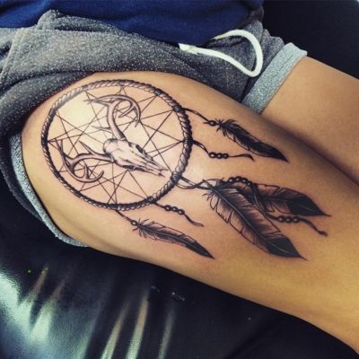  Tatouage attrape rêve avec un crane et des cornes sur le haut de la cuisse